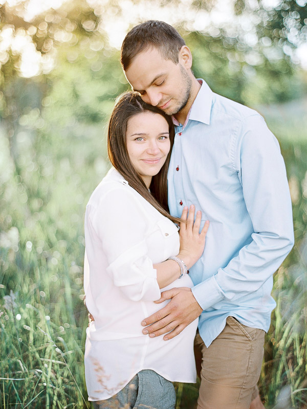 Fotografia kobiety w ciąży z mężem zachód słońca w lesie