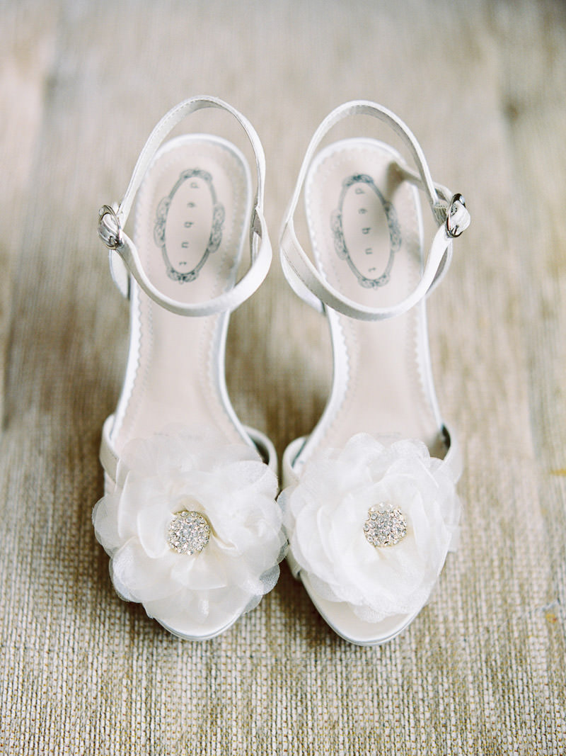 Białe buty ślubne z kwiatami na palcach eleganckie na obcasie