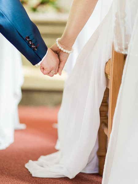 Para młoda trzyma się za ręce ślub kościelny Poznań