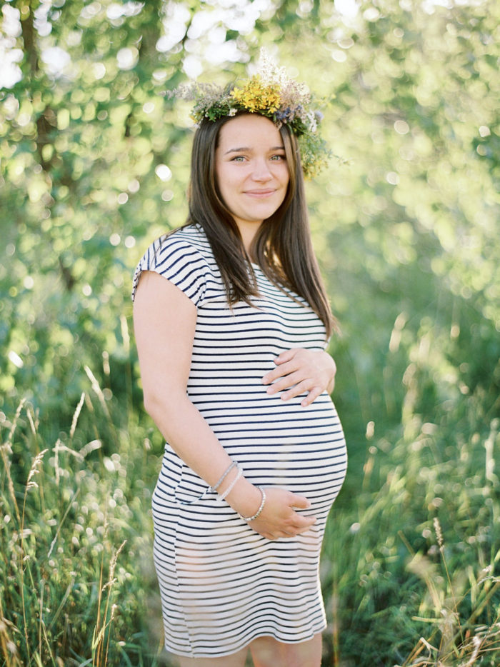 Młoda kobieta w ciąży z wiankiem na głowie