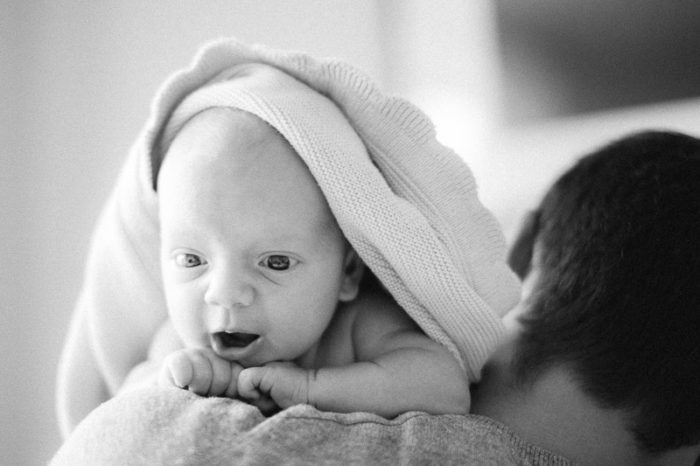 Szczęśliwy noworodek na ramieniu ojca